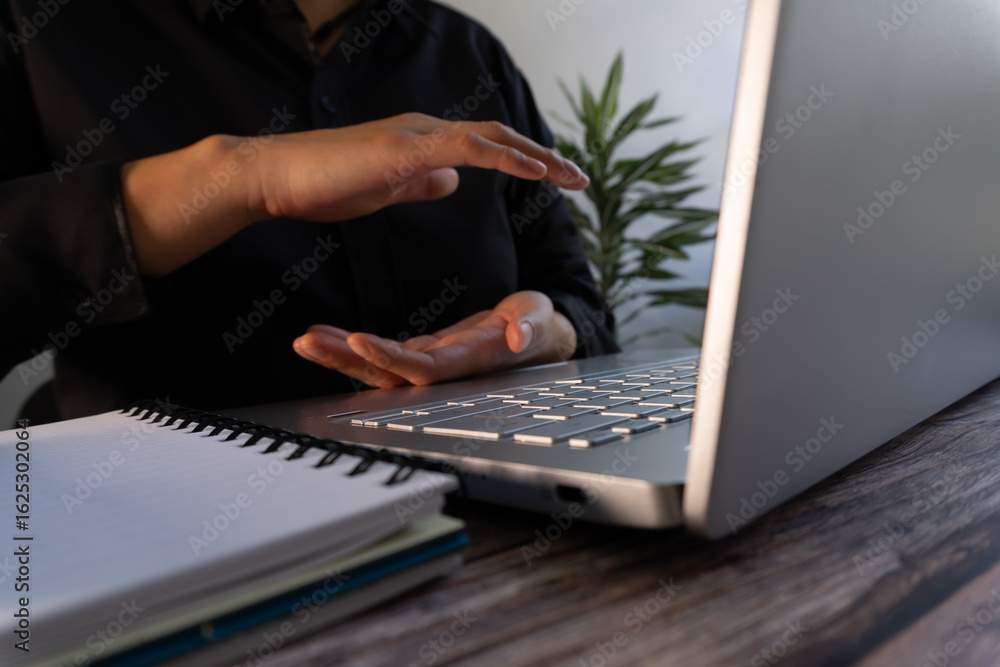 Poster person in front of a computer with his hands protecting something between them