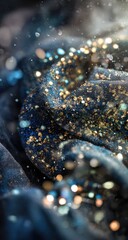 Close-up of a draped, textured fabric, deep blue with gold glitter. Sparkling highlights and out-of-focus glitter particles create a festive atmosphere