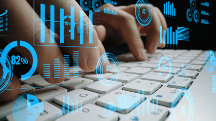Dynamic representation of hands typing on a keyboard enhanced by blue data visualizations and...