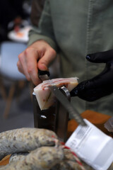 experto cortador de jamón cortando lonchas de tocino beicon con cuchillo especial de corte