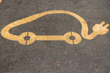 Electric cars, the charging station is indicated by the car symbol and charging cable. The space is reserved for electric charging, a symbol on the pavement of parking lots on city streets. news