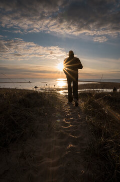 Person walking on the beach towards the sunset. Kalajoki, Finland