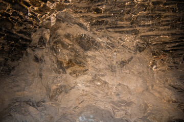 Natural rock formation with textured patterns in warm underground lighting