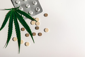 one cannabis leaf and pills on a light background. Alternative medicine