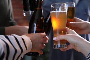 Friends having refreshing beer at home, closeup