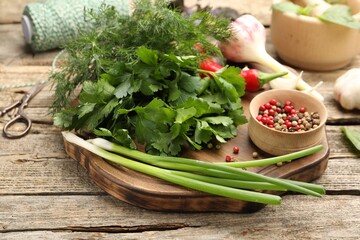 Different fresh herbs, spices, scissors and thread on wooden table, closeup