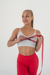 Young woman measuring her chest circumference on white background.