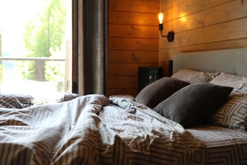 Comfortable bed near window in hotel room