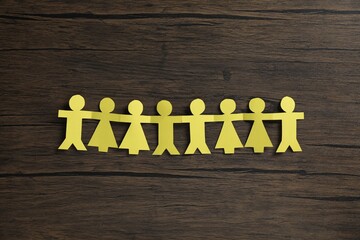 Human paper figures holding hands on wooden background, flat lay