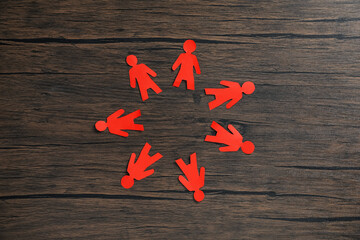 Human paper figures on wooden background, flat lay