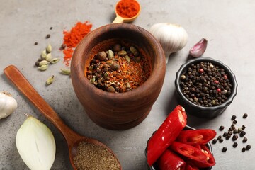 Different aromatic spices on gray textured table, closeup