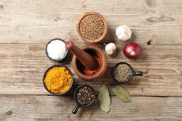 Different aromatic spices on wooden table, flat lay