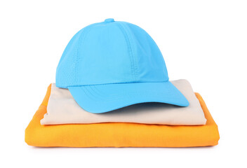 Light blue baseball cap and stack of folded t-shirts isolated on white. Mockup for design