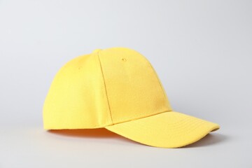 One yellow baseball cap on grey background, closeup. Mockup for design