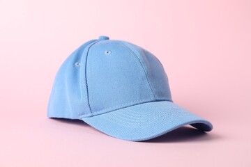 One light blue baseball cap on pink background, closeup. Mockup for design