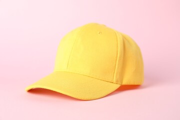 One yellow baseball cap on pink background, closeup. Mockup for design