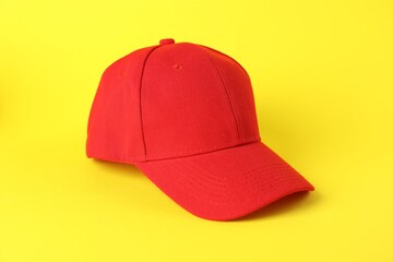 One red baseball cap on yellow background, closeup. Mockup for design