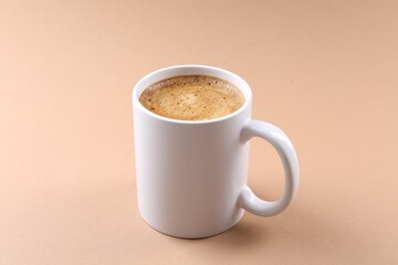Aromatic coffee in cup on beige background, closeup. Mockup for design