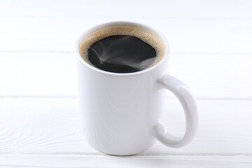 Aromatic coffee in cup on white wooden table, closeup. Mockup for design
