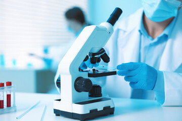 Medical analysis. Scientist working with microscope in laboratory, selective focus