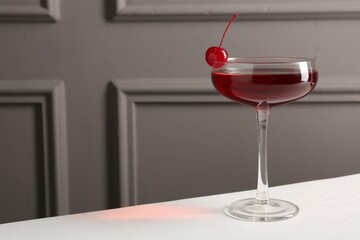 Tasty cherry cocktail on white table, closeup. Space for text