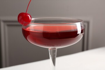 Tasty cherry cocktail on white table, closeup