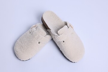 Pair of stylish slippers on white background, above view