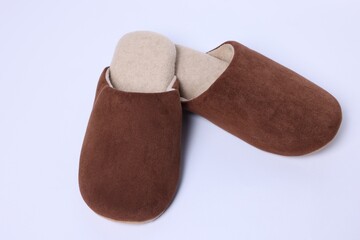 Pair of stylish brown slippers on white background, closeup
