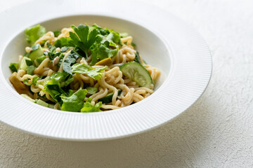 Asian noodle salad in white plate in close-up