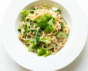 Asian noodle salad in white plate in close-up