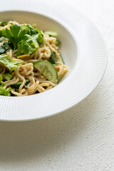 Asian noodle salad in white plate in close-up