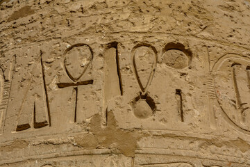Egyptian ancient hieroglyphs on the stone wall. Closeup of the symbol of eternal life ankh