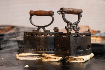 an old iron used to make some special flat pancakes filled with cheese, ham and more