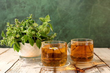 Lemon mint tea on a wooden table, a bouquet of wild medicinal herbs, a collection of useful herbs for treatment according to folk recipes. Alternative medicine concept, green pharmacy advertisement.