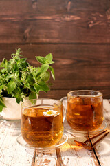 Lemon mint tea on a wooden table, a bouquet of wild medicinal herbs, a collection of useful herbs for treatment according to folk recipes. Alternative medicine concept, green pharmacy advertisement.