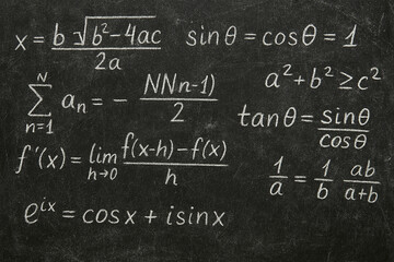 Mathematical formulas written on a black chalkboard background.