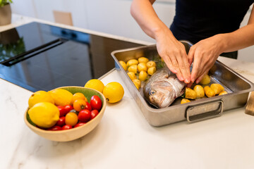 Preparing Snapper Fish With Potatoes and Lemon in a Modern Home Kitchen Setting