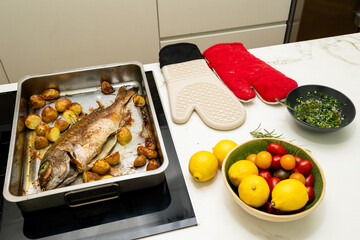 Delicious Home-Cooked Snapper Fish with Roasted Potatoes and Fresh Ingredients on a Kitchen Counter