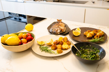 Fresh Snapper Fish Meal with Roasted Potatoes, Lemon, and Herbs in Modern Kitchen Setup