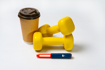 Dumbbells,  cup of coffee and insulin pen on a white background. A concept for a healthy lifestyle, morning workout.