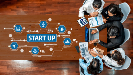 A diverse team of professionals engages in a collaborative discussion about a startup business plan, surrounded by digital graphics emphasizing innovation and growth strategies. Amity