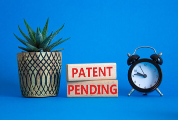 Patent Pending symbol. Wooden blocks with words Patent Pending. Beautiful blue background with...
