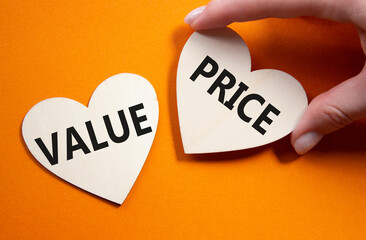 Price and Value symbol. Concept word Price and Value on wooden hearts. Businessman hand. Beautiful...