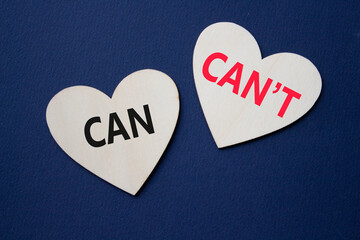 Can or Cant symbol. Concept word Can or Cant on wooden hearts. Beautiful deep blue background....