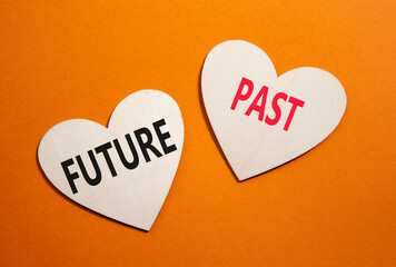 Future or Past symbol. Concept word Future or Past on wooden hearts. Beautiful orange background....