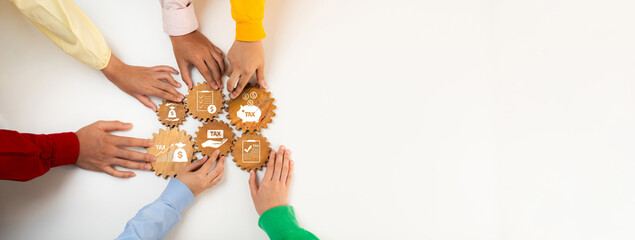 A diverse group of hands collaborates over wooden gears on a white surface, symbolizing teamwork...