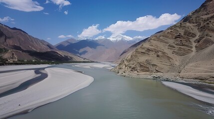 Scenic view of the Indus River, a historic waterway flowing through Pakistan and India, featuring calm waters, fertile riverbanks, traditional boats, rural villages, and lush vegetation