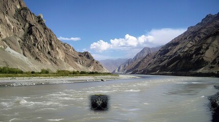 Scenic view of the Indus River, a historic waterway flowing through Pakistan and India, featuring calm waters, fertile riverbanks, traditional boats, rural villages, and lush vegetation