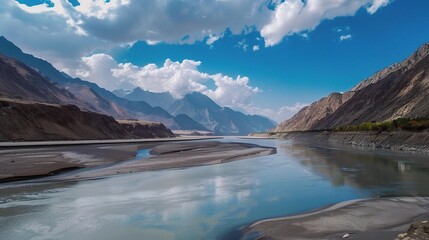 Scenic view of the Indus River, a historic waterway flowing through Pakistan and India, featuring calm waters, fertile riverbanks, traditional boats, rural villages, and lush vegetation