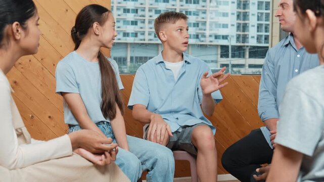 Attractive boy sharing experience during attend in group therapy. high school student talking about way to recovery stress while surrounded with multicultural friend listeing carefully. Edification